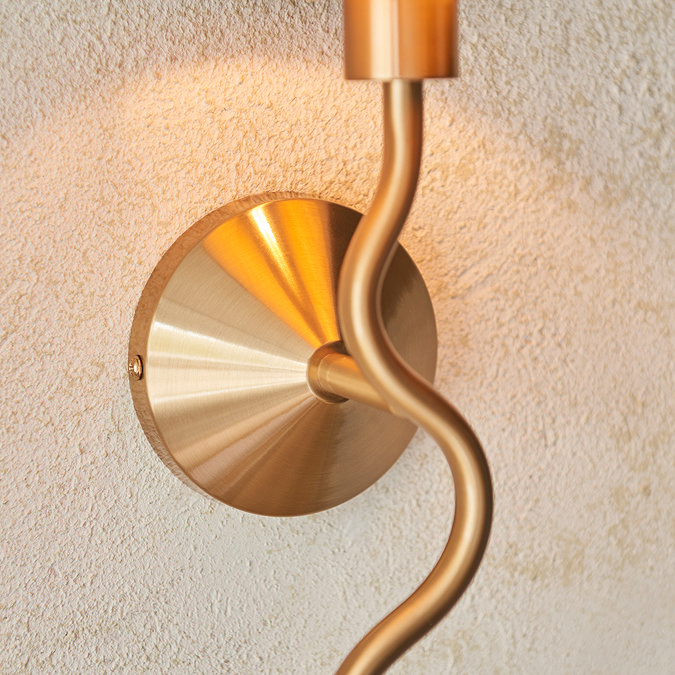 close up on brushed brass wriggle-shaped body of wall light