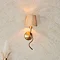 image of wriggle wall light on cream wall, emitting warm glow