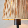 close up on raffia shade of matt black wriggle wall light, showing where shade meets black steel body