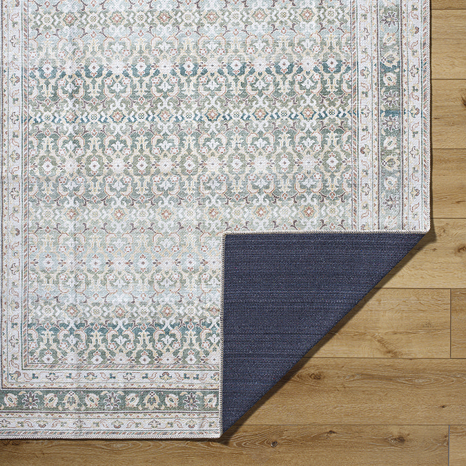 image of corner of green rug folded over in corner to show material underneath