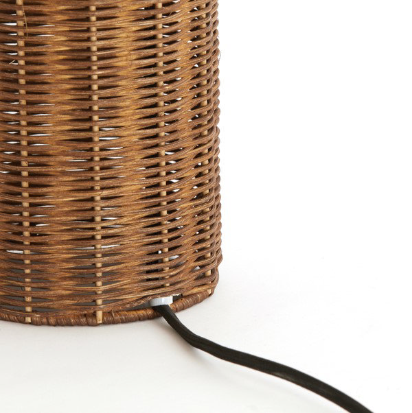 close up on base of brown rattan lamp with thin black cable extending from the back