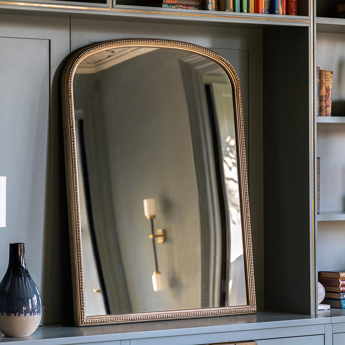 image of arched champagne coloured mirror in the middle of a shelving duck egg blue unit