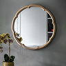 image of champagne gold rounded mirror on grey wall