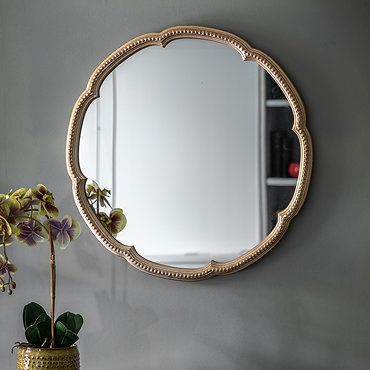 close up image of left side of champagne gold wall mounted mirror, focus on beaded edge detail