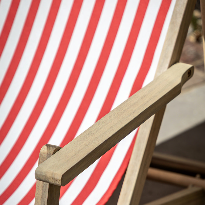 close up image of acacia wood armrests of red and white stripe deckchair