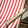 close up image of acacia wood armrests of red and white stripe deckchair
