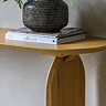 close up on corner of light oak console table with smooth round edge