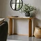 light oak console table at the back of a living room with a bowl and plant on