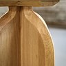 close up on curved leg of light oak side table