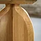 close up on curved leg of light oak side table