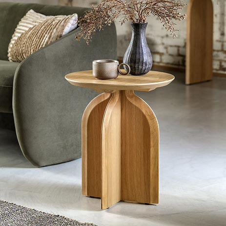image of light oak veneer oval side table next to a grey sofa, topped with faux plant and brown mug