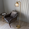 image taken from above of satin brass curved floor lamp with dimpled champagne glass shade