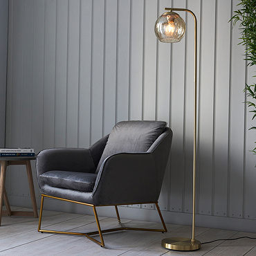 image taken from above of satin brass curved floor lamp with dimpled champagne glass shade