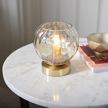 close up on dimpled champagne glass of table light