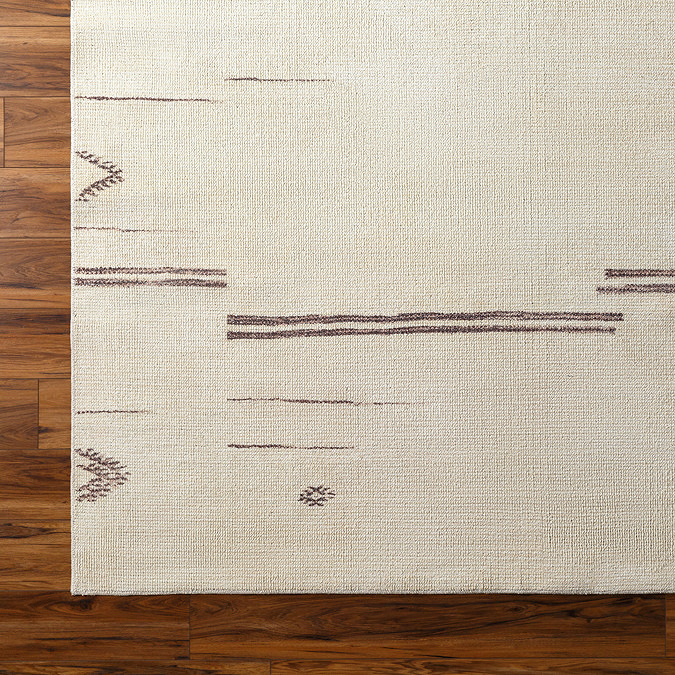 close up image of cream rug with charcoal boho asymmetrical line pattern