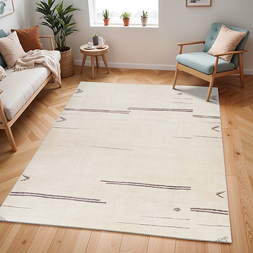 close up image of cream rug with asymmetrical charcoal boho line pattern, ruched up slightly to show its thinness
