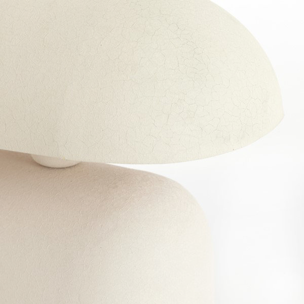 close up image on edge of smooth curved cream table lamp