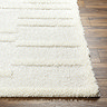 close up image on corner of super soft cream rug on wooden flooring