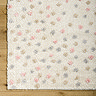 close up on corner of cream rug dotted with multi coloured spots