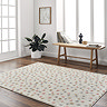 image of cream super soft rug patterned with multi coloured dots, on dark wooden flooring of home office in front of low bench and window