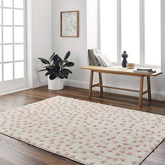 image of super soft cream rug with pink spots on, on wooden flooring of home office next to low bench