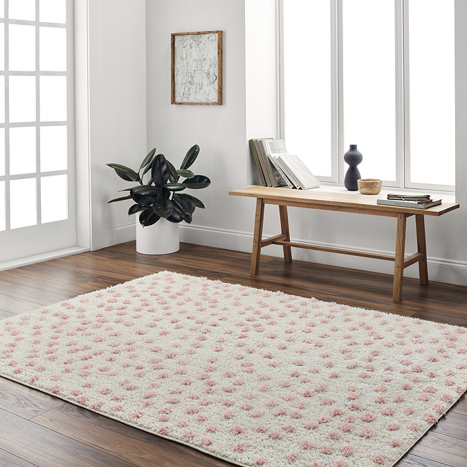 image of super soft cream rug with pink spots on, on wooden flooring of home office next to low bench