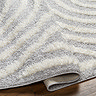 close up image of folded edge of soft grey rug, indicating its thickness/height