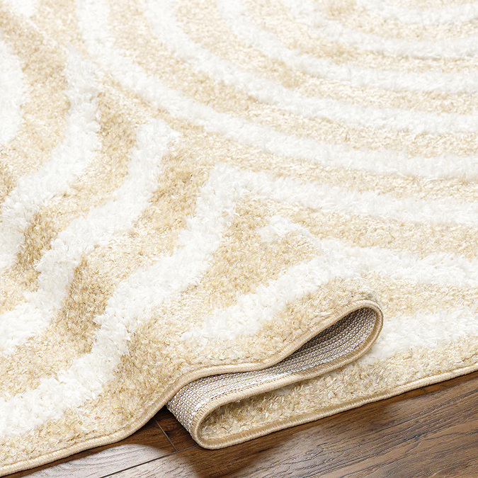 close up image on folded edge of soft yellow rug, indicating its height