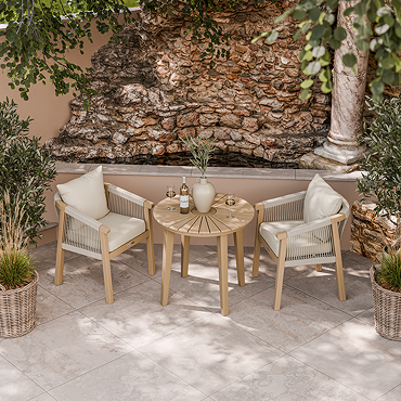 close up image of woven rope dining table tucked under round acacia wood bistro table
