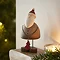 rustic wooden small santa decoration, holding a small wooden star and stood on the edge of a light oak mantlepiece.