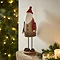 tall rustic santa stood on an oak mantlepiece, surrounded with candles and a small garland. 