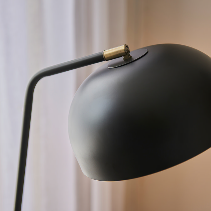 close up image on matt black metal domed shade of tall floor lamp