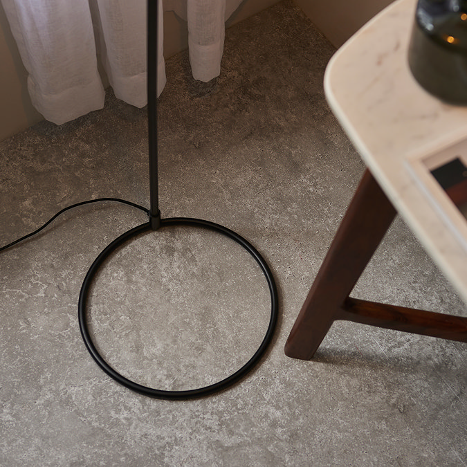close up on modern circular base of thin matt black floor lamp