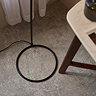 close up on modern circular base of thin matt black floor lamp