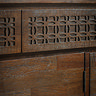 super close up image of frieze on warm brown sideboard