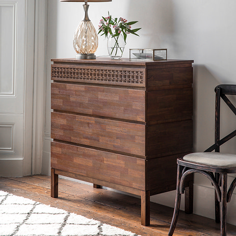 side on image of 4 drawer chest with warm brown finish and frieze on top drawer