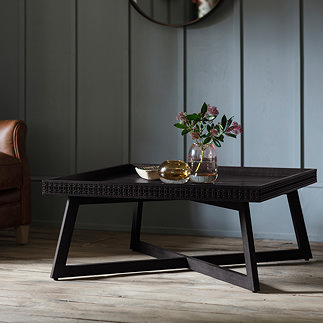 image of black wooden coffee table with bohemian frieze pattern, on wooden flooring