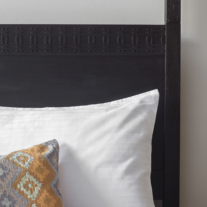 close up image of black headboard of four poster bed