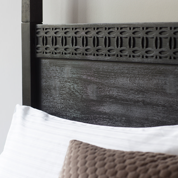 close up image of frieze pattern across top of four poster bed