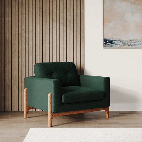 lifestyle image of green velvet armchair with light ash feet