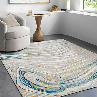 image of marbled teal and beige rug in modern apartment living room, under a grey armchair in front of a window