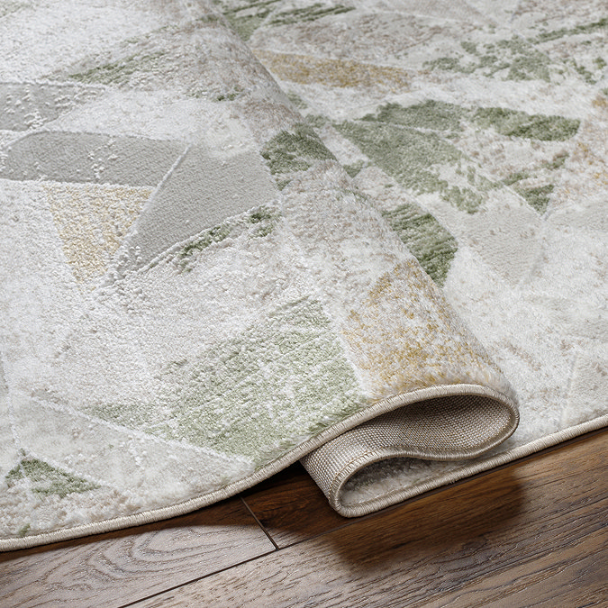 image of sage and ivory geometric rug folded slightly to suggest its thickness