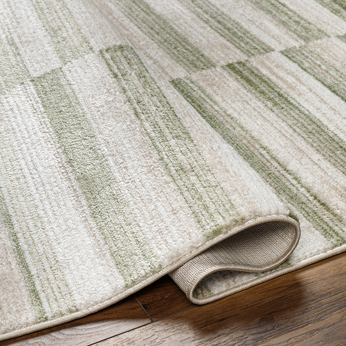 image of striped green and ivory rug folded slightly