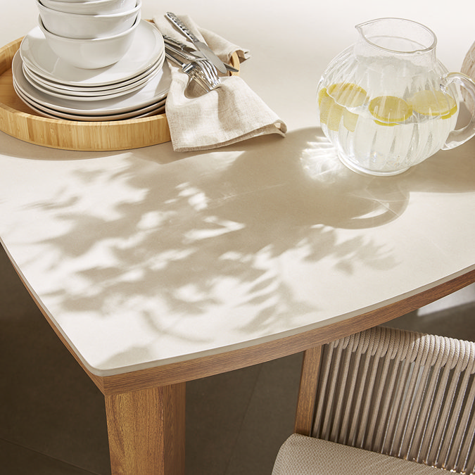 close up image of sintered stone tabletop of cream dining table with light wood legs