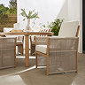 close up image of rope backed cream dining table tucked under matching sintered stone dining table
