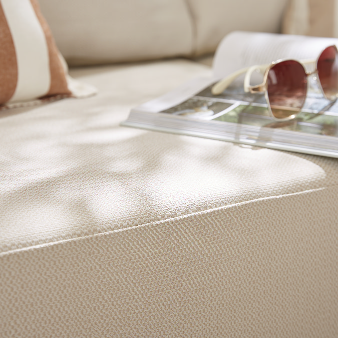 close up image on plush cream cushion of garden sofa