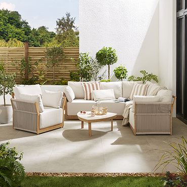 image angled slightly from above of luxury garden lounge set with deep cushions and cream stone topped coffee table