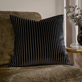 55x55cm black cushion with vertical stripe detail, sat on khaki chair