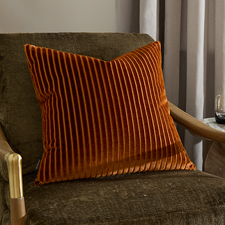 55x55cm brick orange cushion with vertical stripe detail, sat on dark khaki armchair
