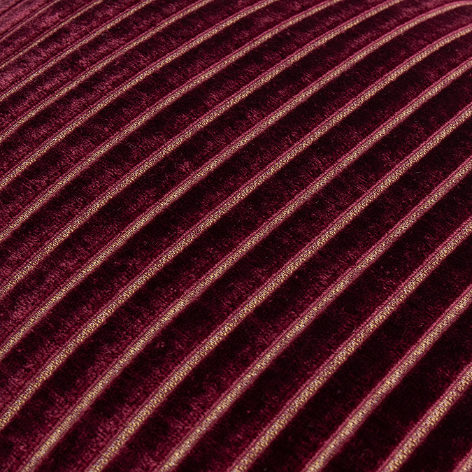 close up on burgundy cushion with gold stripe pattern
